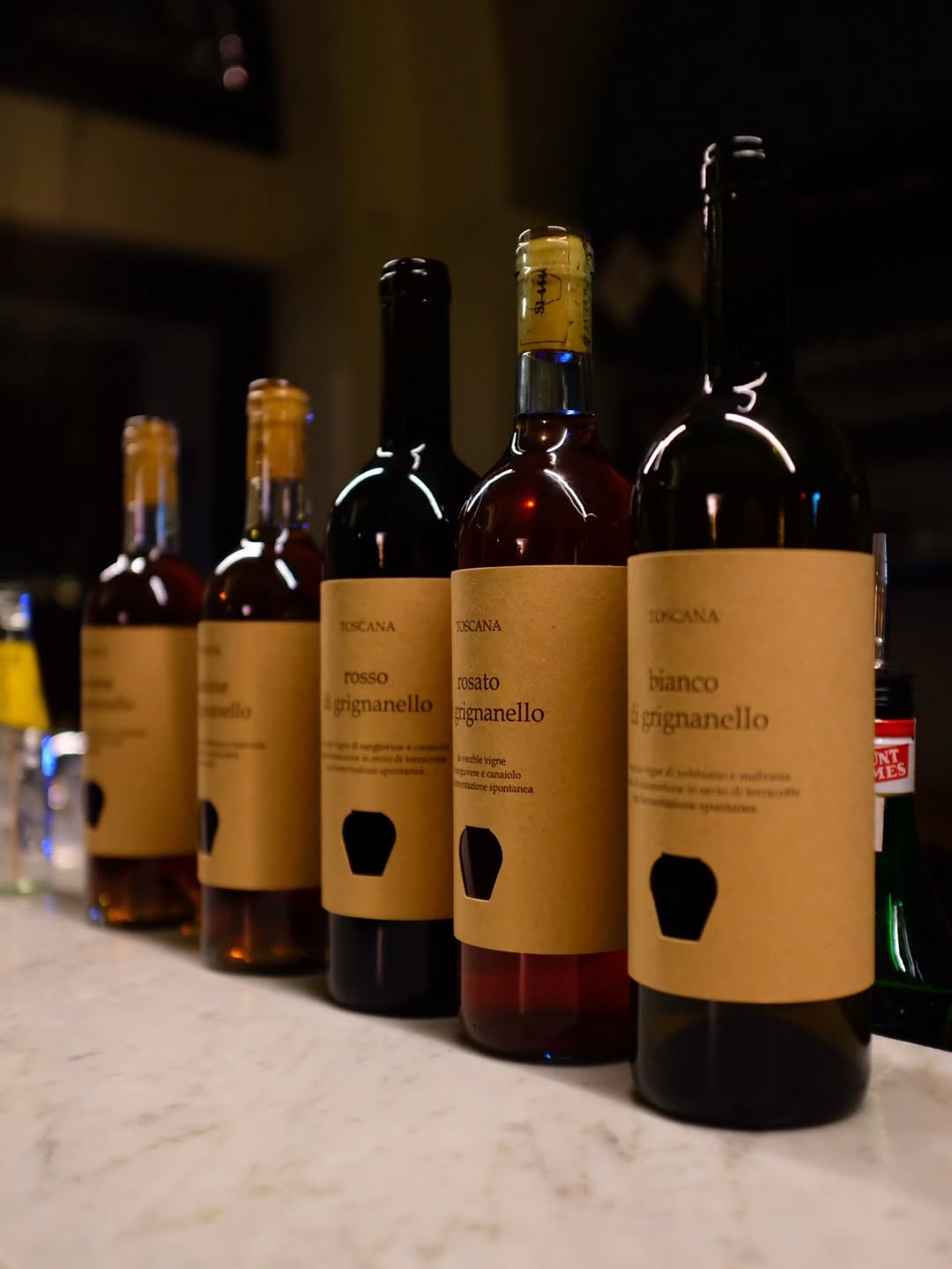 bottiglie di rosso - rosato e bianco di grignanello e due vini dolci - con etichette di carta kraft