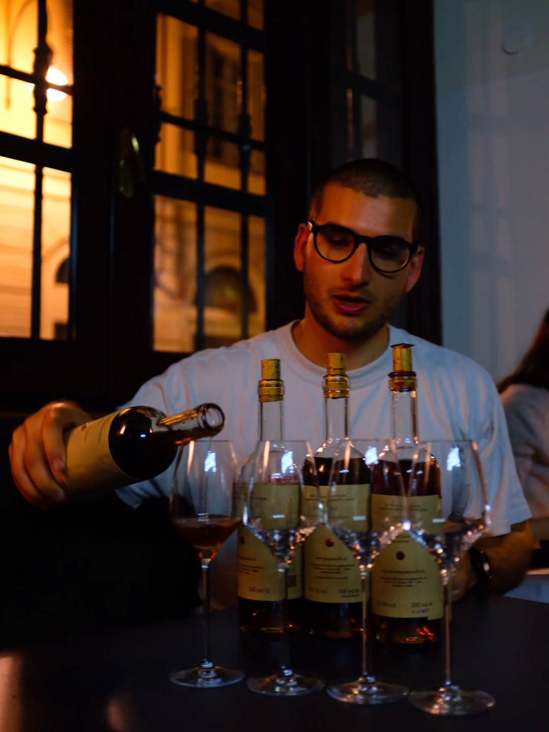 verkostung - ein süßer wein wird vor drei flaschen in gläser eingeschenkt